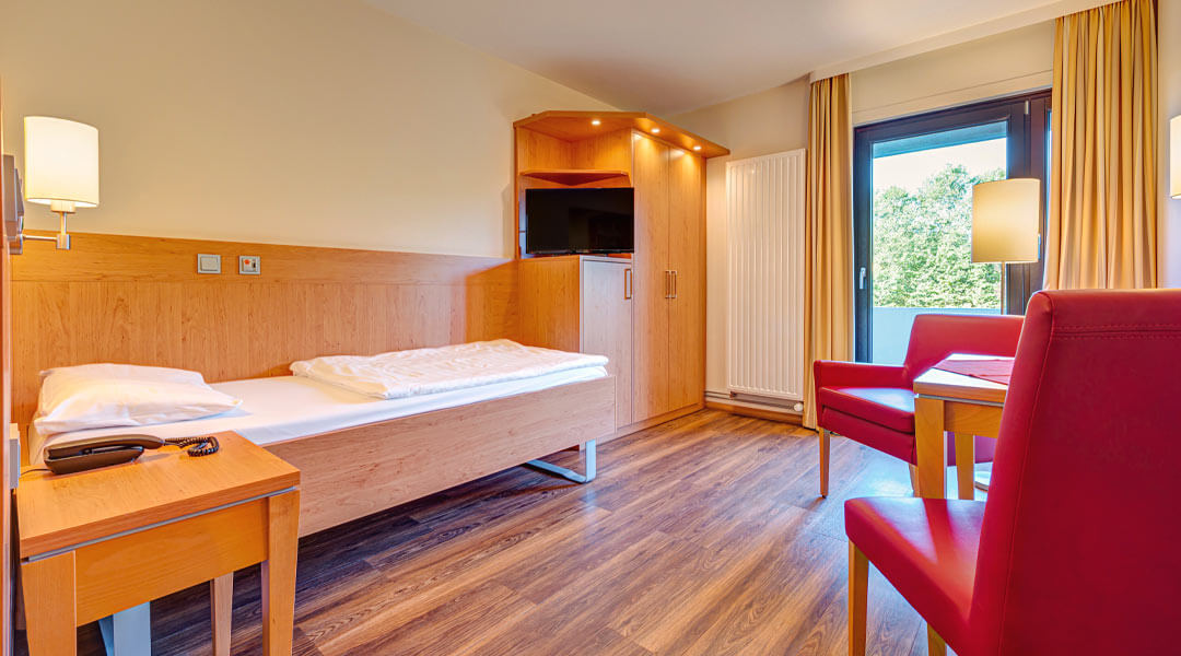 Patientenzimmer mit Bett und TV in der Caspar Heinrich Klinik